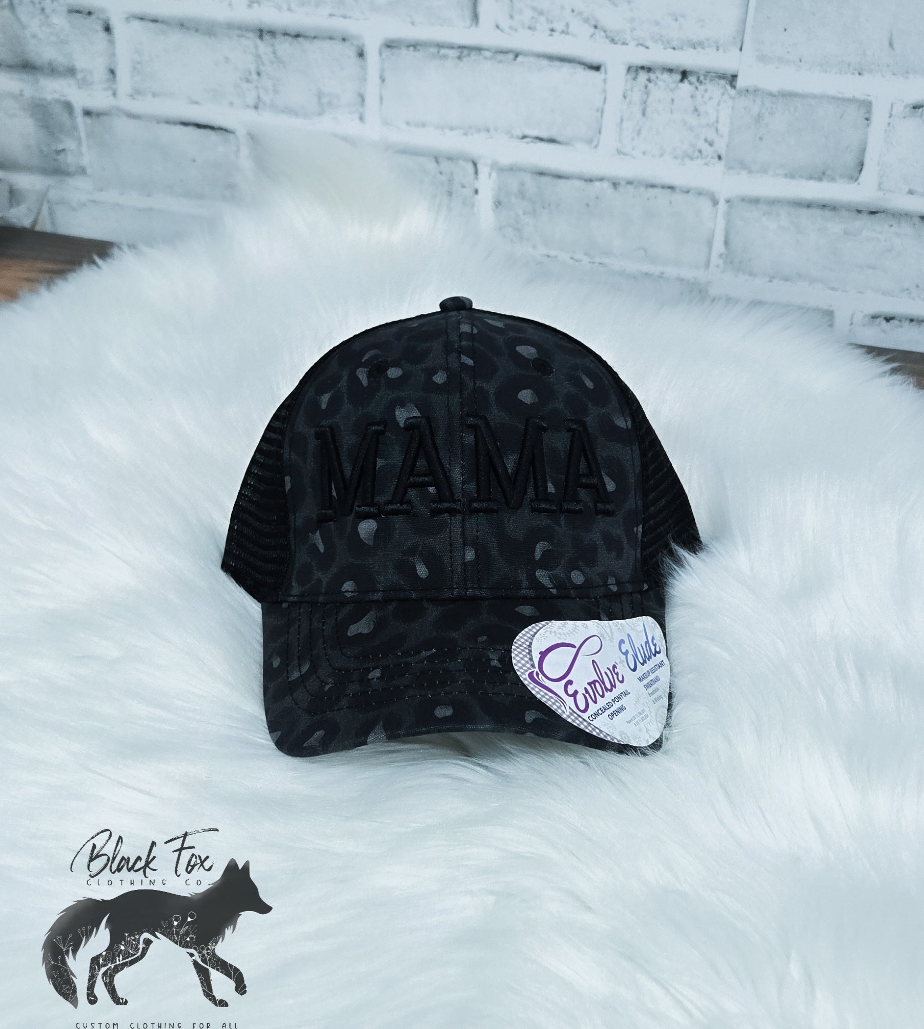 A black leopard print trucker hat with 'MAMA' embroidered in capital letters on the front.