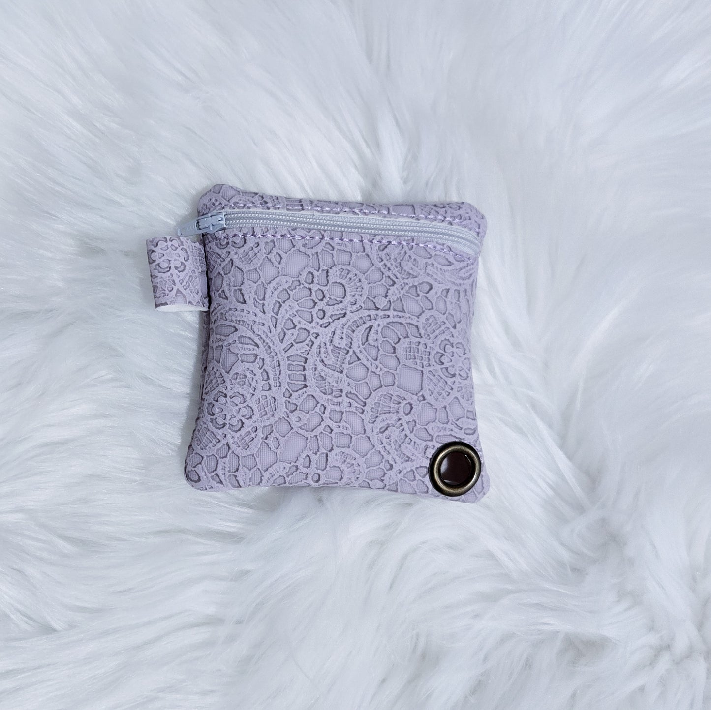 Purple lace pouch on a white fluffy surface